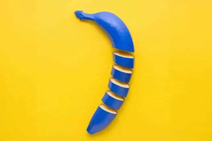 A blue banana over a yellow background
